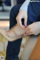 A woman is putting on a pair of shoes.