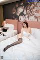 A woman laying on a bed in a hotel room.